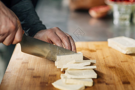 准备素食厨师手用木板上的刀切豆腐奶酪手用刀切豆腐奶酪木板上的刀切图片