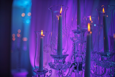 喜庆式的婚礼桌有燃烧的蜡烛和紫色光晶体水蜡烛架作为婚礼招待会的中心部分喜庆式的婚礼桌是招待会的中心部分图片