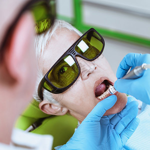 一名高级女牙医在诊所修的肖像高级科护理图片