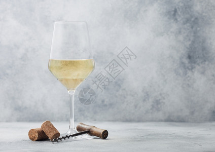 夏日白葡萄酒和软木杯放在浅色桌底背景上图片