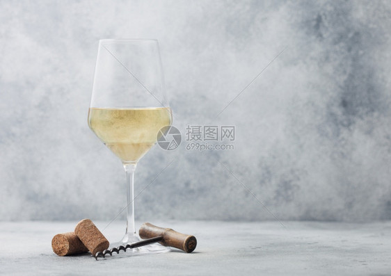 夏日白葡萄酒和软木杯放在浅色桌底背景上图片