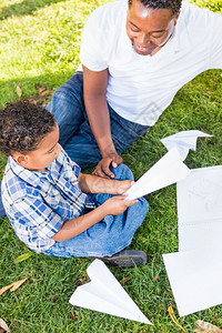 美国父亲和混血儿在公园玩纸飞机图片