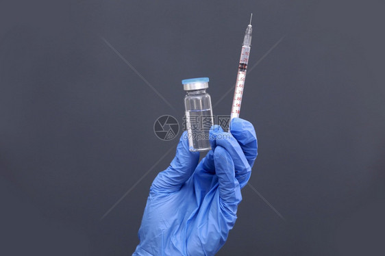 医生、护士或科学家手持蓝硝基套,持流感、麻疹为疾病爆发接种疫苗注射的冠状病毒疫苗、药品和物概念。 医生、护士或科学家手持蓝色硝基图片