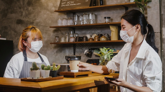 咖啡馆的消费者用热咖啡纸杯取走拥有小生意图片