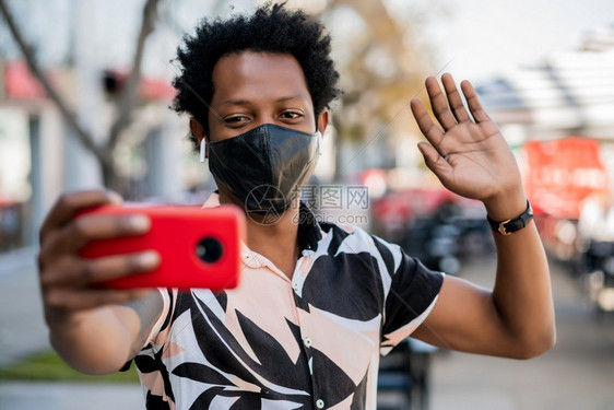 afro观光客在露天宿街头时用手机进行视频通话的肖像新正常生活概念旅游图片