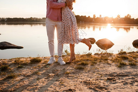 情侣在日落时的湖边拥抱图片