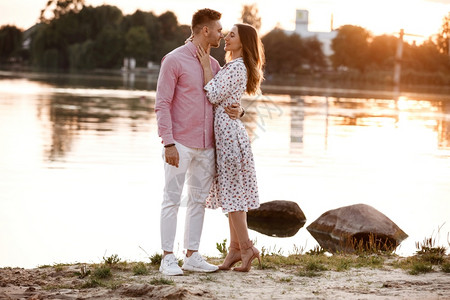 情侣在日落时的湖边约会图片素材