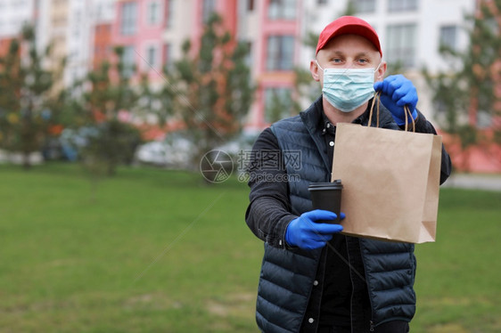 身戴红色帽子的送货员面戴医疗罩手套将纸袋拿掉图片