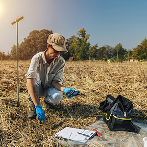 女农学家测量实地土壤温度环境保护项目的实地工作图片