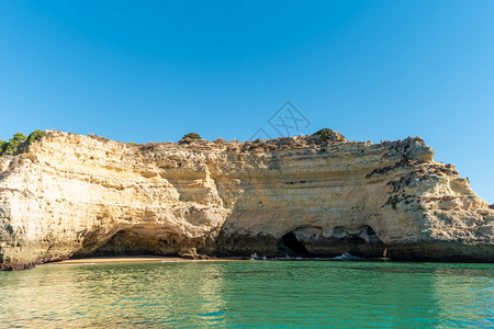 位于阿尔加夫地区Portugal海岸的7个悬吊山谷和绿海水的岩石悬崖拱门图片