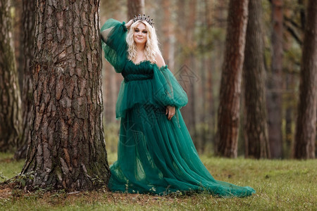 美丽的年轻金发女皇公主走秋天绿林神秘古老的中世纪闪亮王冠长夜绿衣神奇的幻想年轻美丽的金发女皇图片