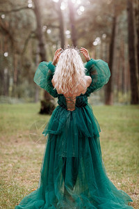 美丽的年轻金发女皇公主走秋天绿林神秘古老的中世纪闪亮王冠长夜绿衣神奇的幻想后视镜年轻美丽的金发女皇魔法的幻想图片