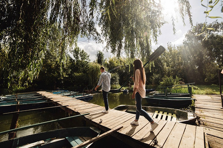 时髦的男女在阳光明媚的湖上享受独木舟图片