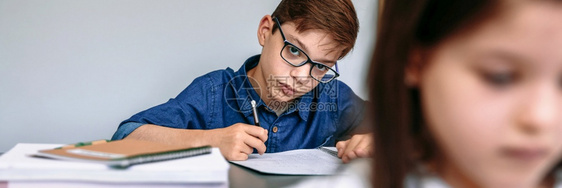 青少年在学校的笔记本上写字图片