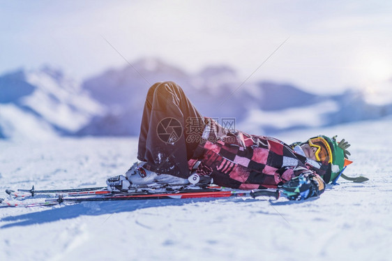 小男孩躺在山顶滑雪胜地上图片