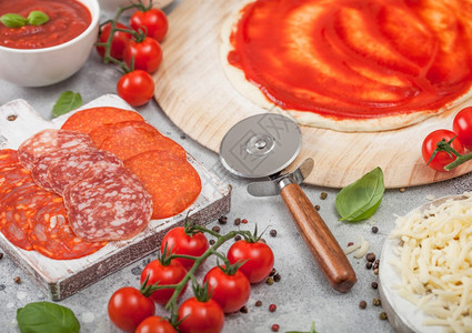 准备用生面粉烤番茄比萨饼香辣焦索切轮机新鲜西红柿和用芝士番茄糊的碗盘烤面包图片