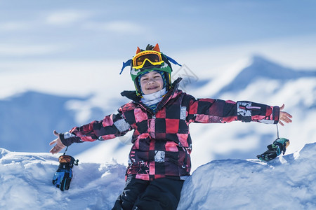 男孩躺在山顶滑雪胜地上图片