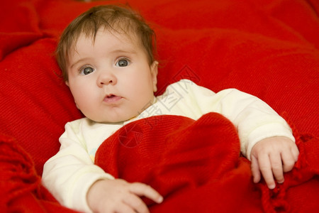 盖着红毯子的女婴儿图片