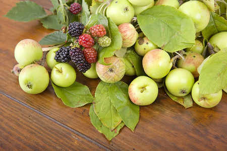 木制桌上的苹果和草莓图片