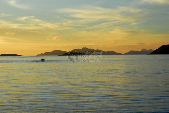 日落时船在海岸附近图片