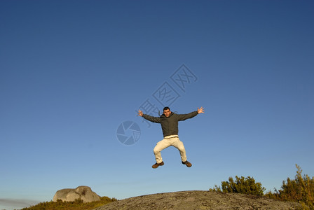 年轻人在山上高跳跃图片