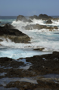 海岸的岩石上有海浪的图片