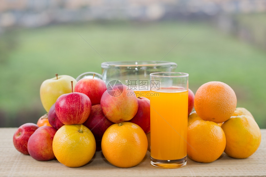 橙汁杯子和木桌外许多水果图片