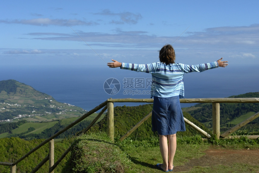 在海岸开阔的双臂张幸福女子图片