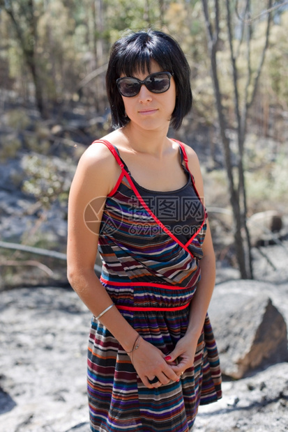 年轻临时女青装扮对着镜头微笑户外高清图片下载-正版