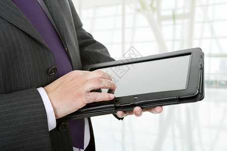 商人使用触碰垫在办公室的平板电脑上闭合镜头图片