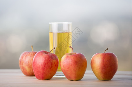 户外木制桌上的苹果和汁图片