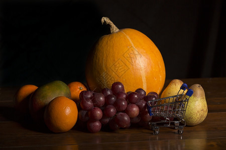 各种水果和一张木制桌子工作室图片上的小购物车图片