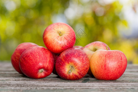 秋天bokeh背景的木桌上苹果图片