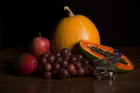 各种水果和一张木制桌子工作室图片上的小购物车图片