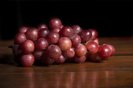 一堆红葡萄木本底的红葡萄图片