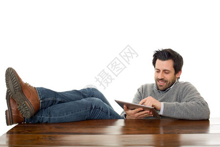 快乐的男子在桌上用平板电脑孤立图片