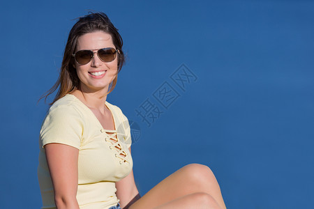 年轻快乐的女士坐在岩石山上放松和享受湖水在古尔斯葡萄牙公园图片