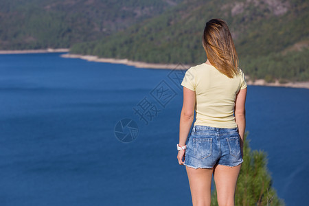 在山上快乐的年轻女子放松和享受湖在Gers葡萄牙公园女孩享受湖图片