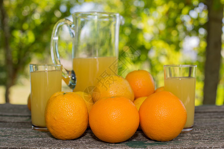 美味的橙汁和放在花园的桌上图片