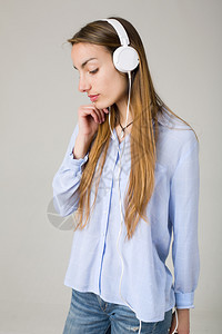 美丽的年轻女子用耳机听音乐图片