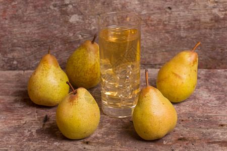 软啤梨梨子和一杯果汁放在木制桌子上工作室照片梨子和果汁背景