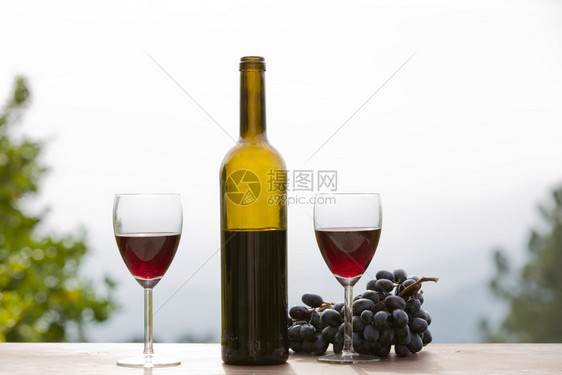 户外木制桌上的葡萄酒和葡萄图片