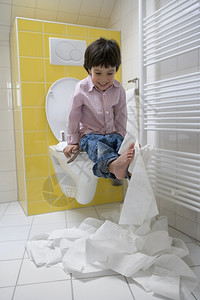 小男孩在厕所里弄脏了卫生纸图片