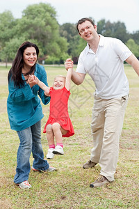 可爱的情侣在公园里和快乐的女儿玩耍自然背景图片