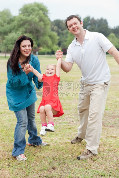 可爱的情侣在公园里和快乐的女儿玩耍自然背景图片