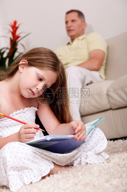一个可爱的女孩和父亲一起做家庭作业图片