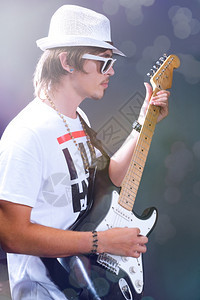 一个年轻吉他手拿着表演舞台背景图片