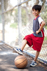 小可爱男孩腿脚下打篮球装模作样图片