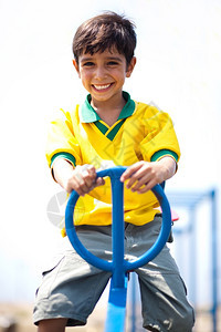 身穿足球制服的男孩在公园玩耍摇摆中骑车图片