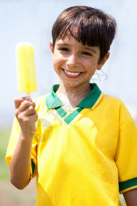 微笑的孩子拿着冰淇淋看摄像机图片